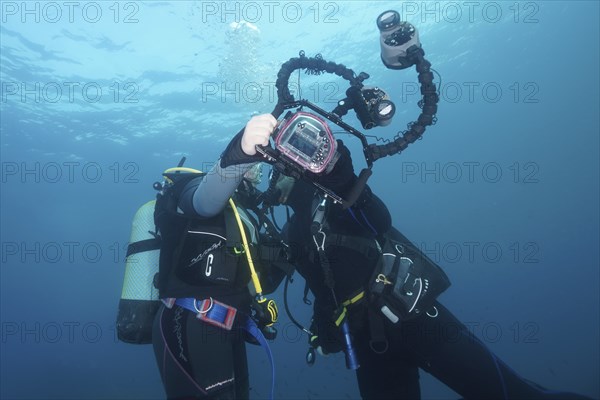 Two divers take a photo, selfie, underwater with a camera. Dive site Marine reserve Cap de Creus,