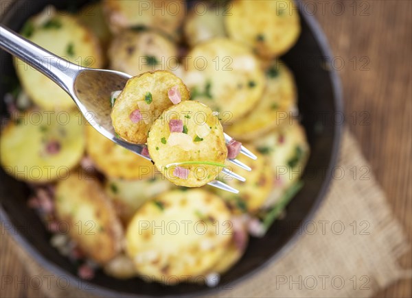 Portion of fresh homemade Fried Potatoes on an old wooden table (selective focus, close-up)