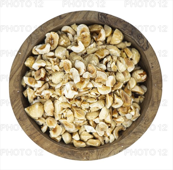 Freshly chopped Hazelnuts as detailed close up shot isolated on white background (selective focus)