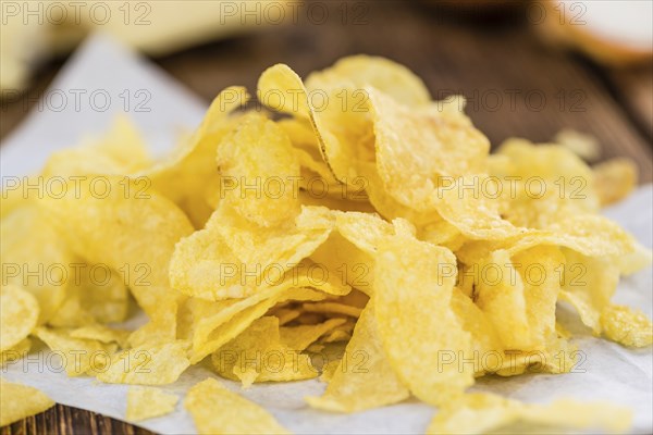 Homemade Cheese and Onion Potato Chips on vintage background (selective focus, close-up shot)