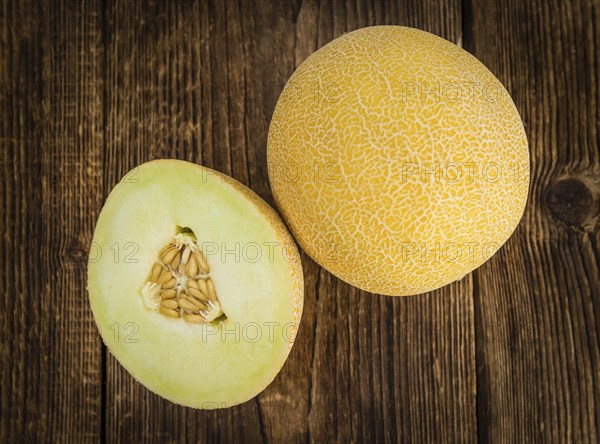 Honeydew Melon on an old wooden table as detailed close-up shot (selective focus)