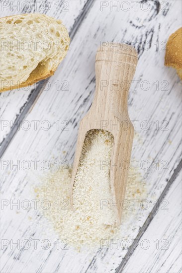 Old wooden table with fresh Breadcrumbs (close-up shot, selective focus)