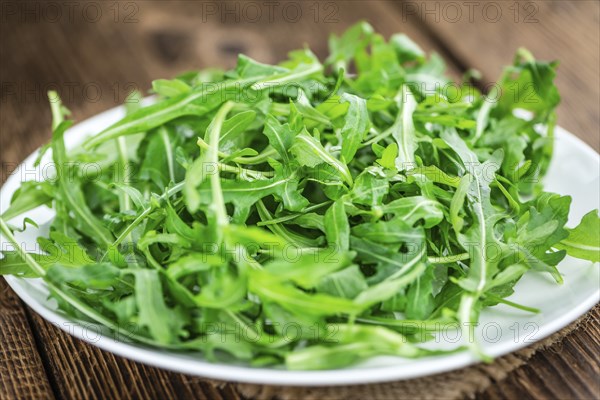 Fresh Arugula on an old wooden table as detailed close-up shot