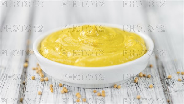 Portion of homemade Mustard on wooden background (selective focus, close-up shot)