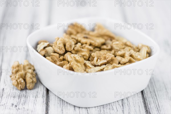 Walnuts (kernels) on an old wooden table as detailed close-up shot (selective focus)