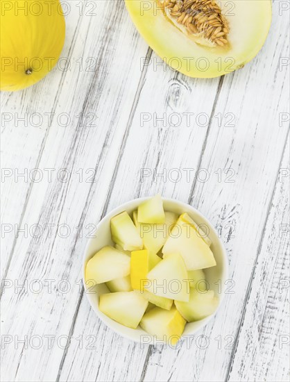 Fresh made Yellow Honeydew Melon on a vintage background (close-up shot)