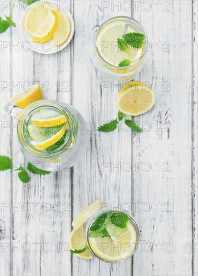 Homemade Lemonade on an wooden table (selective focus) as detailed close-up shot