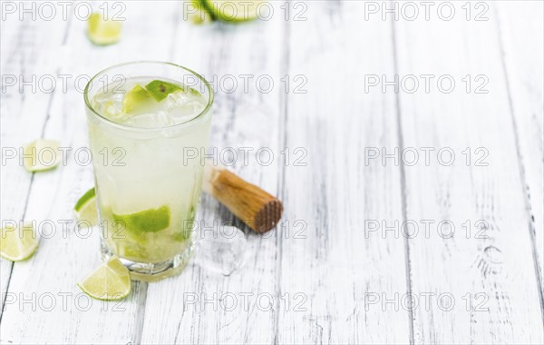 Caipirinha made with fresh limes, ice and sugar as close-up shot