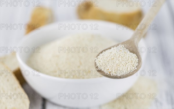 Some Bread Crumbs on a vintage wooden table (selective focus, close-up shot)