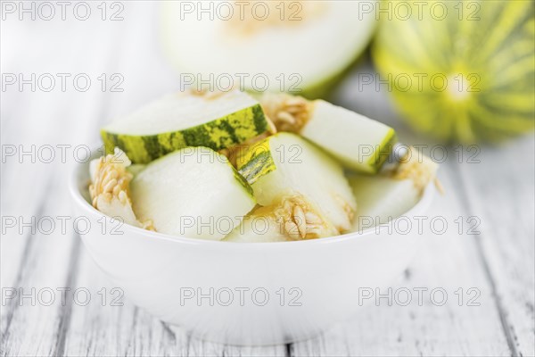 Fresh Futuro Melon as high detailed close-up shot on a vintage wooden table (selective focus)