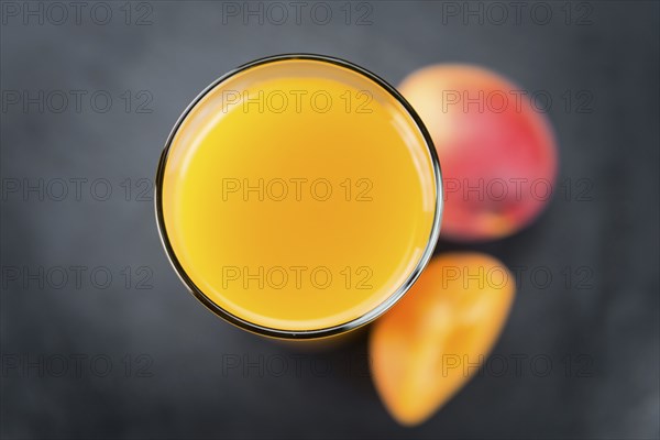 Some fresh Apricot Juice on a vintage slate slab (selective focus, close-up shot)
