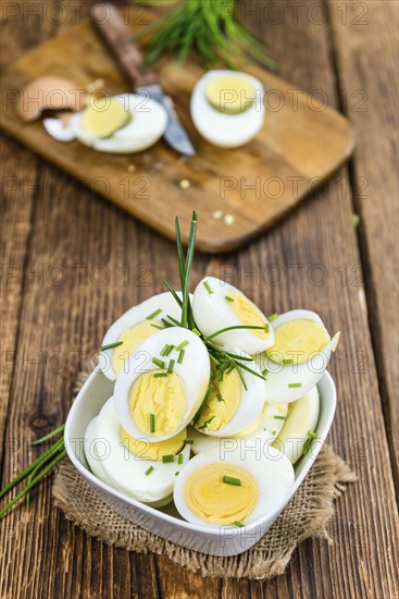 Halved Eggs on wooden background (close-up shot, selective focus)