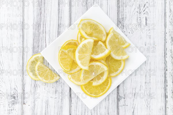 Homemade Lemon Slices on an wooden table (selective focus) as detailed close-up shot