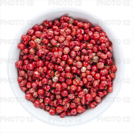 Portion of Pink Peppercorns as detailed close-up shot isolated on white background