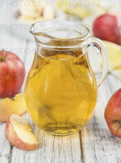 Apple Cider on an old wooden table as detailed close-up shot (selective focus)