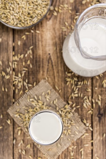 Healthy Oat Milk on a wooden table as detailed close-up shot (selective focus)