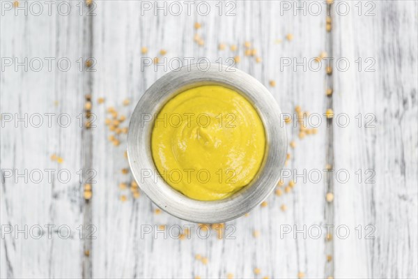 Portion of homemade Mustard on wooden background (selective focus, close-up shot)