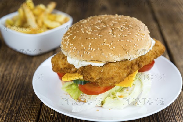 Homemade Fish Burger (close-up shot, selective focus) on a wooden table