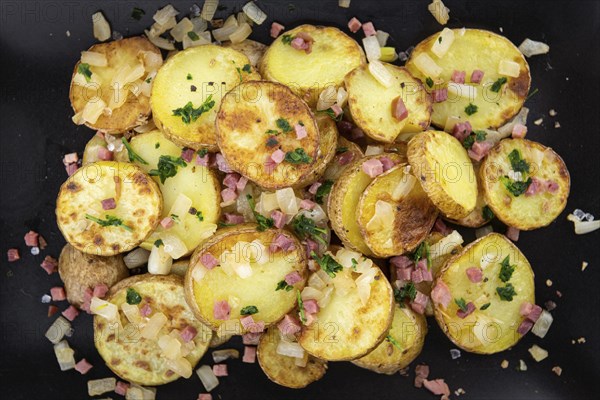 Portion of fresh homemade Fried Potatoes on an old wooden table (selective focus, close-up)