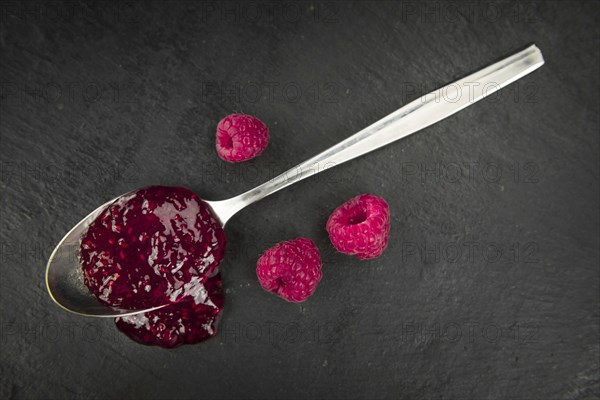 Some Raspberry Jam on a slate slab as detailed close-up shot, selective focus