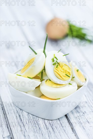 Halved Eggs on wooden background (close-up shot, selective focus)