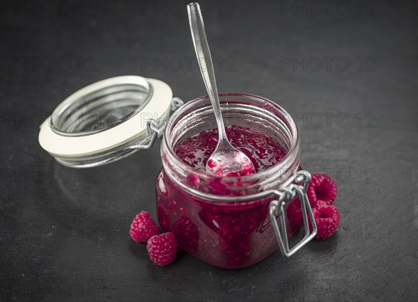 Some Raspberry Jam on a slate slab as detailed close-up shot, selective focus