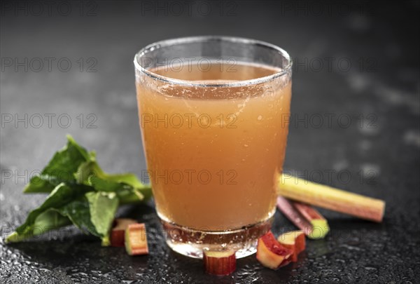 Rhubarb Juice on a rustic background (close up shot, selective focus)