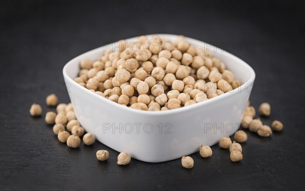 Some dried Chickpeas on a slate slab as detailed close-up shot, selective focus
