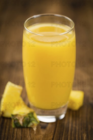 Fresh made Pineapple Juice on an old and rustic wooden table, selective focus, close-up shot
