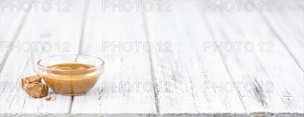 Portion of fresh Caramel Sauce (close-up shot, selective focus)