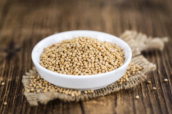 Mustard Seeds on rustic wooden background (close-up shot)