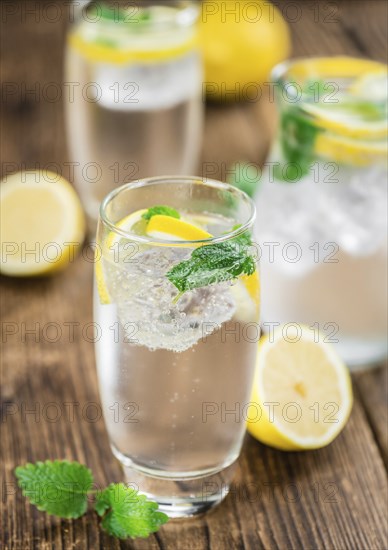 Homemade Lemonade on an wooden table (selective focus) as detailed close-up shot