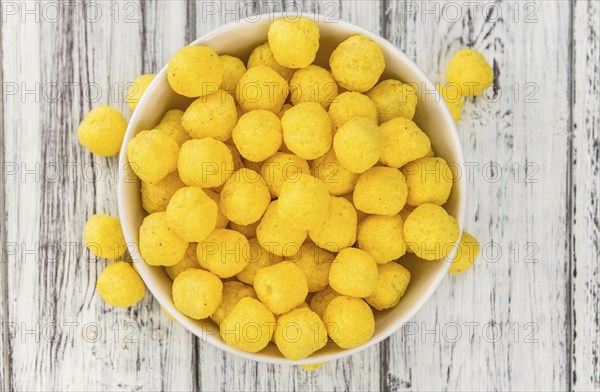 Cheese Balls on rustic wooden background (close-up shot)