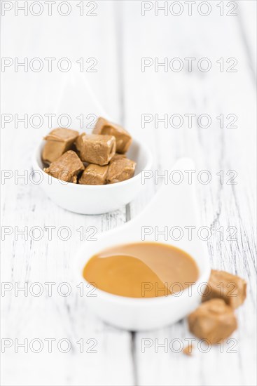 Caramel Sauce on a vintage background as detailed close-up shot (selective focus)