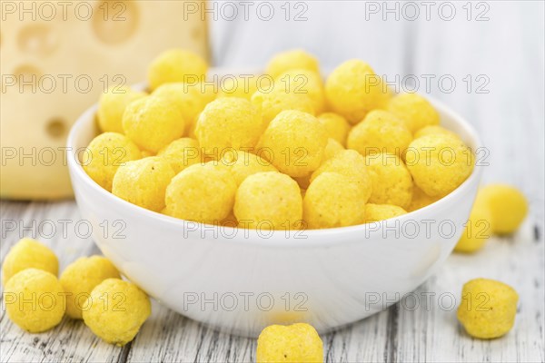 Cheese Balls on rustic wooden background (close-up shot)