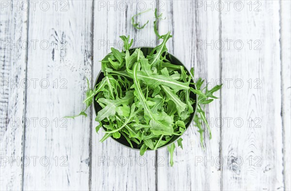 Fresh Arugula (selective focus) as detailed close-up shot on vintage background