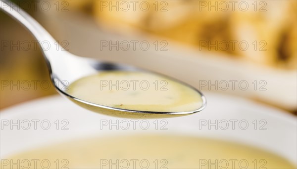 Chanterelle Soup as high detailed close-up shot on a vintage wooden table, selective focus