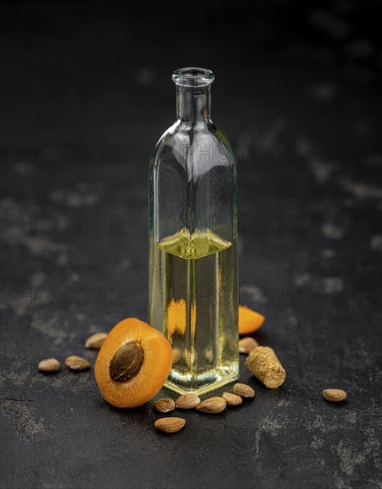 Portion of Apricot Oil with some fresh fruits as detailed close up shot (selective focus)