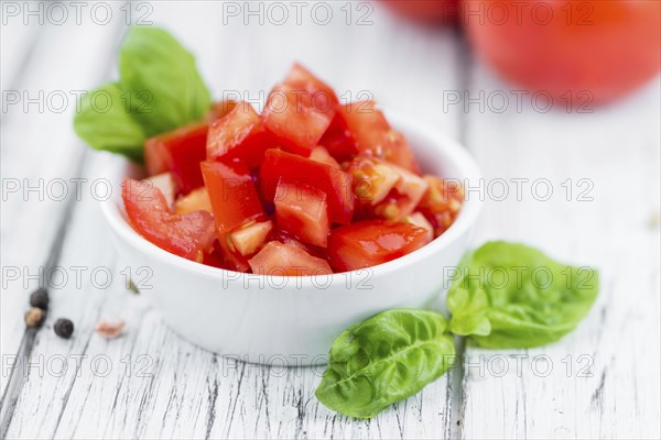 Cutted Tomatoes on an old wooden table as detailed close-up shot (selective focus)