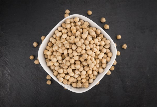 Portion of dried Chickpeas on a rustic slate slab, selective focus, close-up shot