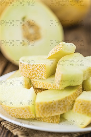 Honeydew Melon on an old wooden table as detailed close-up shot (selective focus)