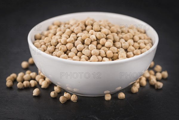 Some dried Chickpeas on a slate slab as detailed close-up shot, selective focus