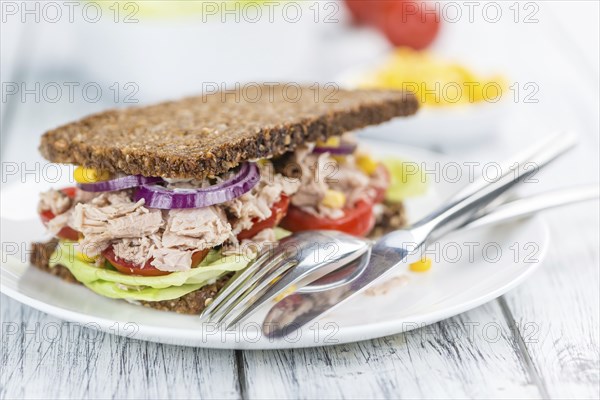 Old wooden table with Tuna sandwich (on wholemeal bread, selective focus)