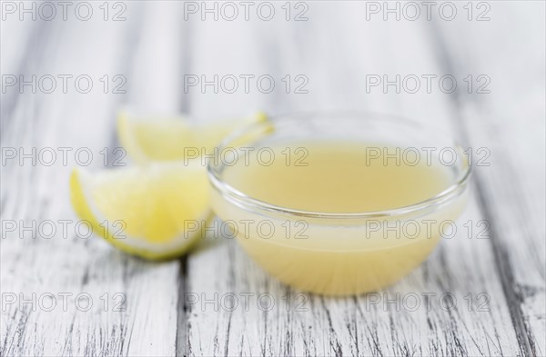 Fresh made Juice (lemon) on an old and rustic wooden table (selective focus, close-up shot)