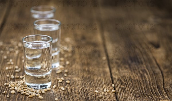 Vintage wooden table with Wheat Liqueur (selective focus, close-up shot)