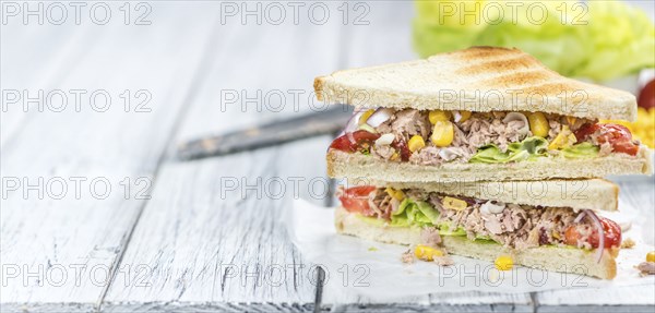 Homemade Tuna Sandwich (selective focus, close-up shot) on vintage wooden background