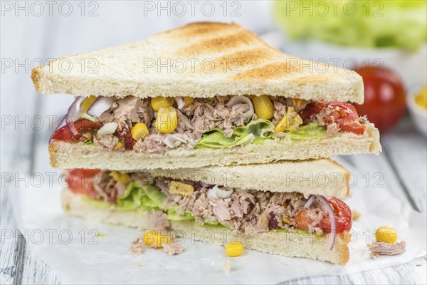 Wooden table with a fresh made Tuna Sandwich (selective focus, close-up shot)