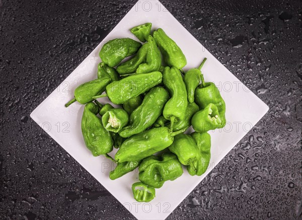 Portion of Raw Pimientos on a rustic slate slab, selective focus, close-up shot