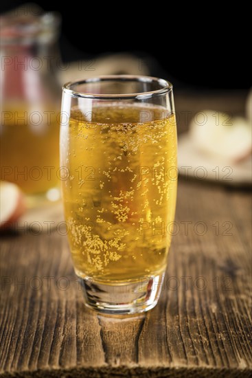 Apple Cider as high detailed close-up shot on a vintage wooden table (selective focus)