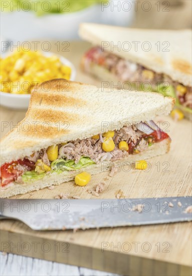 Wooden table with a fresh made Tuna Sandwich (selective focus, close-up shot)